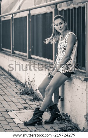 Teenager with skateboard full body portrait. Black and white image.