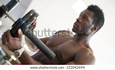 Strong black man adjusting heavy lift on bar in the gym.