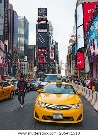 NEW YORK CITY - CIRCA MAY 2015: Yellow cab in Times Square, a busy tourist intersection of commerce Advertisements and a famous street of New York City and US