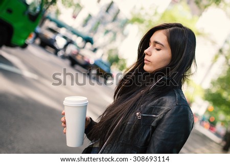 Young woman portrait with a coffee cup in the street. New York City.