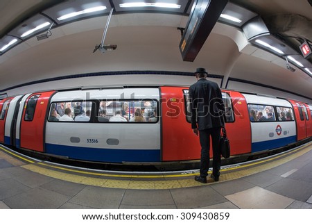 LONDON - JUNE 18, 2015: Businessman entering subway wagon. The Underground system serves 270 stations and has 402 kilometres (250 mi) of track, 45 per cent of which is underground.