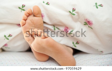 Young kid bare feet in bed.