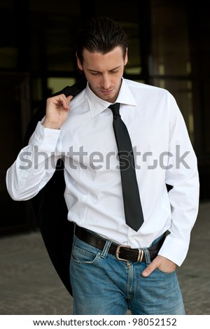Young business man relaxed portrait. Dark background.