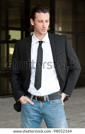 Young business man relaxed portrait. Dark background.