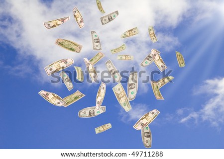 Symbol of wealth and success. Dollars falling from the blue sky.