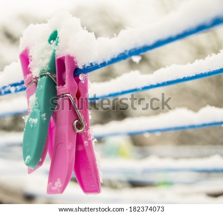 soft focus on clothes pegs on washing line, including snow on top