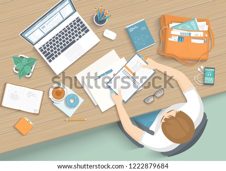 Man sitting at the wooden table. Workplace Desktop Workspace Armchair, office supplies, monitor, books, notebook, headphones, phone, glasses, pen, bag, tea, donut. Vector Top view 