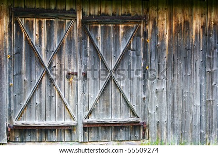 Old closed barn-wood door on wooden background