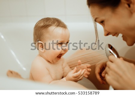 Mother washing shower happy newborn baby in bath 商業照片 © 
