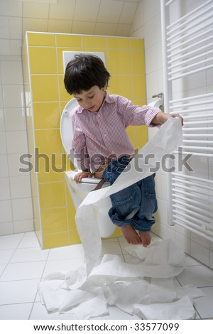 Naughty boy making a mess with toilet paper