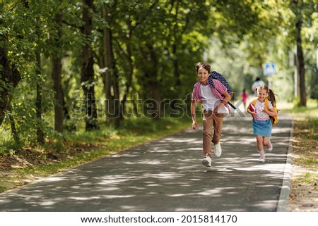 Primary school pupil. boy and girl with backpacks walking down street. Happy children happy to go back to school. beginning school year. Kids are happy to run to school. education.