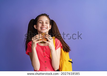 Similar – Foto Bild Hübsches Schulmädchen isst Hamburger und sitzt drinnen in einem Cafe. Glückliches Kind, das Junkfood in einem Restaurant isst. Seitenansicht