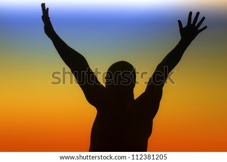 Silhouette of a man with outstretched arms on a rainbow background
