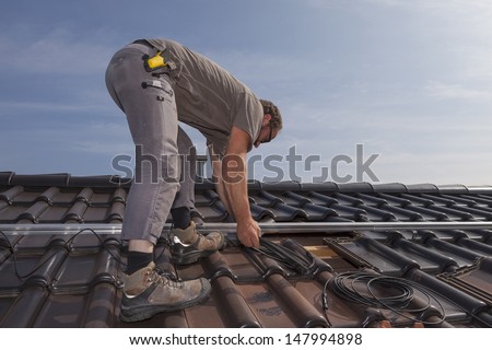 worker preparing the roof to install photovoltaic solar panels.