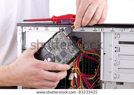 studio-shot of a computer support engineer changing the hard drive of an office computer,isolated on white.