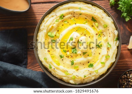 Delicious creamy mashed potatoes with butter, fresh herbs and freshly-cracked black pepper. Top view with close up. Stock foto © 