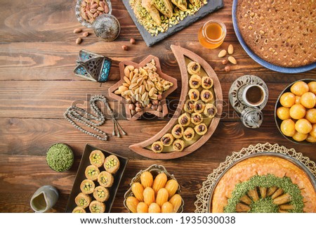 Arabic Cuisine: Middle Eastern desserts. Delicious collection of Ramadan traditional desserts. Served with tasty nuts, Arabic coffee, honey syrup and sugar syrup .Top view with close up.