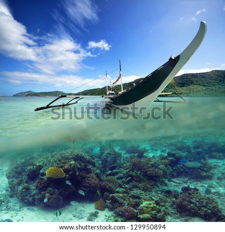 Travel card with Philippine boat on a background of green islands and coral reef.