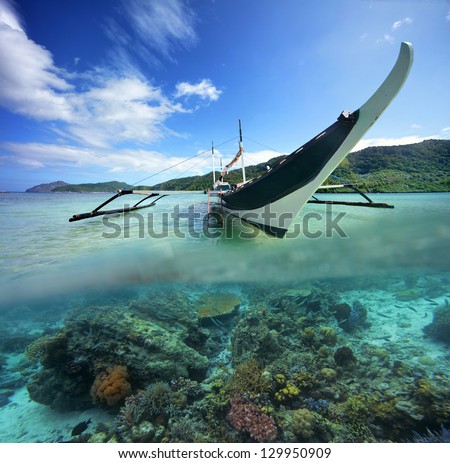 Travel card with Philippine boat on a background of green islands and coral reef in the foreground