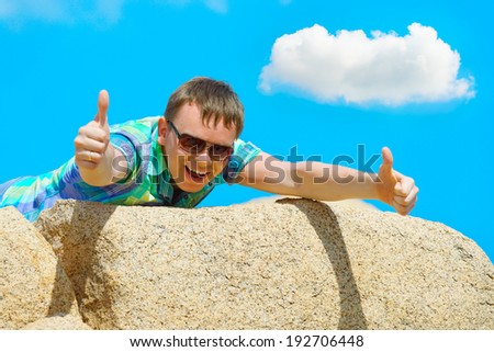 Happy young man lies on the edge of a cliff. Series Emotions / Feelings  #03 photos
