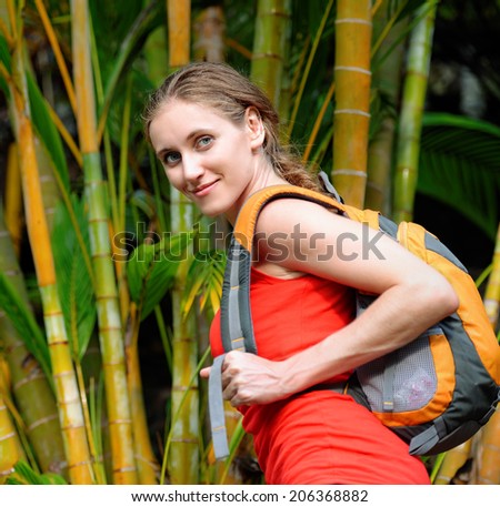 Young tourist with backpack walking in tropical forest. Travel to Asia, happiness emotion, summer holiday concept