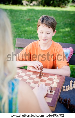 Thinking boy waiting for his next move in a chess game
