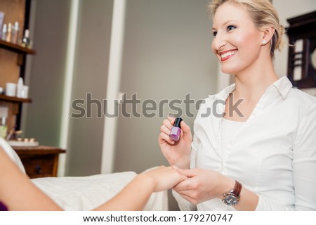 Manicurist shows a sample of a nail polish
