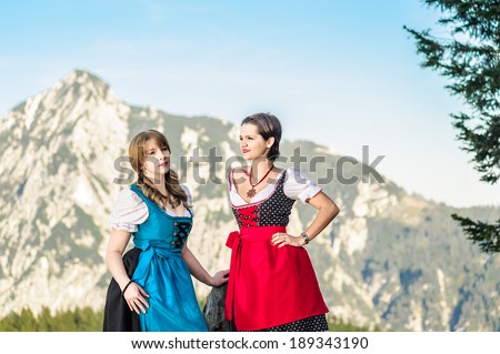 Mountain range and young woman with traditional austrian clothes