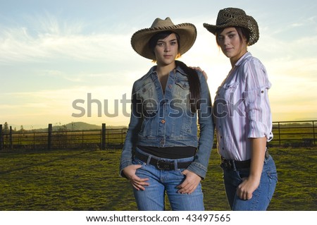 Twin cowgirls in a coral against a fall sunset