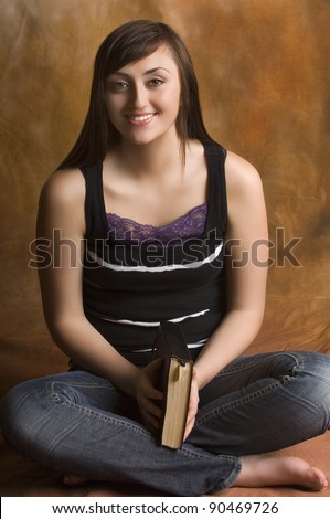 Teen woman praying over Bible on knees with hands folded