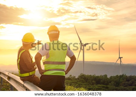 Two engineers discussed the plan for the maintenance of wind turbines. Renewable energy with wind generator by alternative energy concept in Asia
