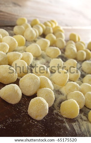 Raw potatoes gnocchi pasta with flour on a wooden table