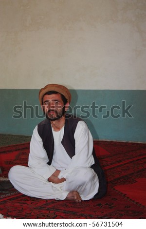BAHARAK, AFGHANISTAN - JUNE 3: Unidentified Afghan man in traditional dress watches public health lecture in his newly built community center on June 3, 2010 in Baharak, Afghanistan