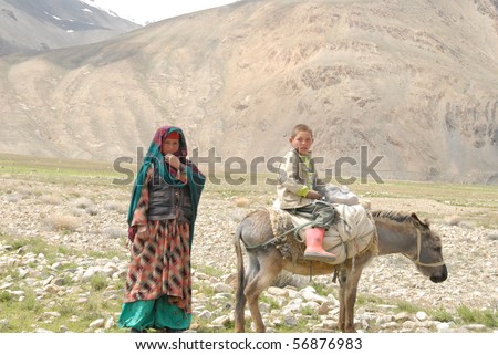 ISHKASHIM, AFGHANISTAN - MAY 31: Mother and son walk home with their donkey on May 31, 2010 in Ishkashim, Afghanistan. This donkey is the family\'s only source of livelihood.