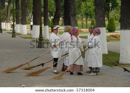 TASHKENT, UZBEKISTAN - MAY 18: Women take a break from sweeping a pedestrian street on May 18, 2010 in Tashkent, Uzbekistan. The street has been cleared of street vendors by Presidential decree.