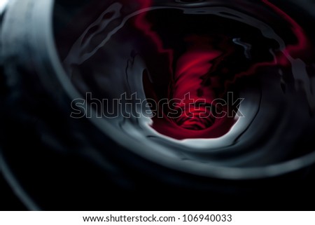 Red wine swirling into a vortex in a wine glass