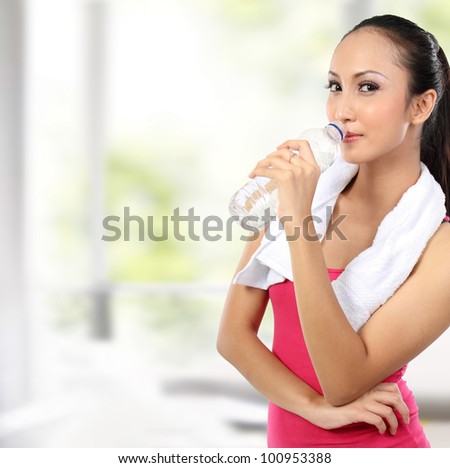 portrait of attractive asian smiling woman drinking water
