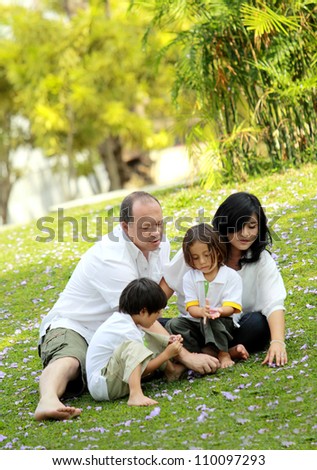 Portrait of happy asian caucasian family in the park