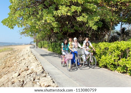 happy asian family riding bicycle outdoor in the morning