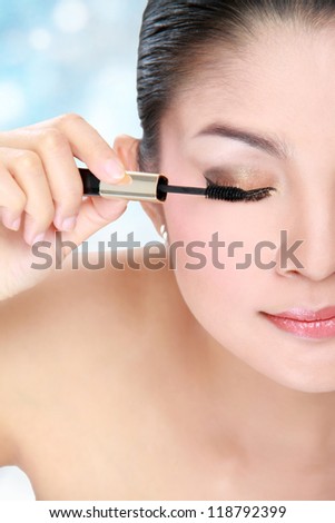 Beautiful woman applying mascara on her eyelashes isolated on white background