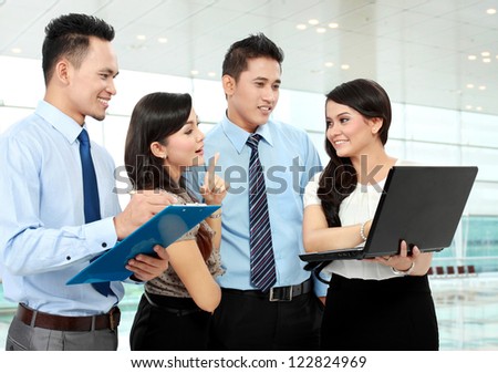 group of happy business people doing presetation with laptop during meeting