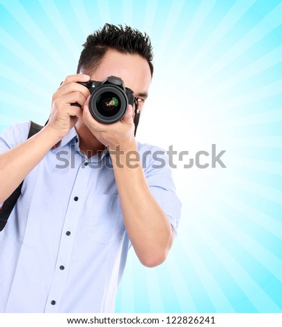 portrait of asian professional photographer ready to take some photo on blue background