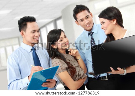 group of happy business people doing presentation with laptop during meeting