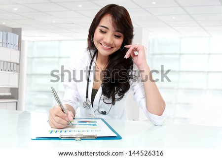 happy young asian doctor working in office