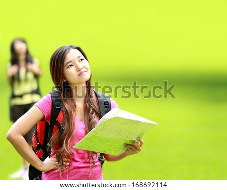 portrait of confuse asian girl camping in the park holding a map