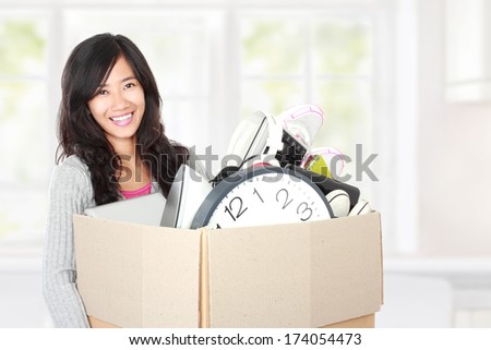 woman with her stuff inside the cardboard box ready to move. moving day concept
