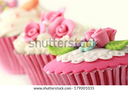 sweet cupcakes decorated with sugar paste and cream