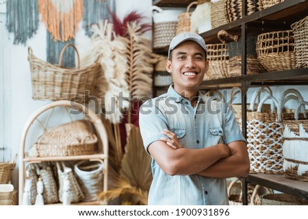Owner a craft business with crossed hands while in a craft shop with handmade crafts on the shelf background