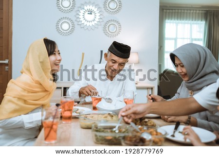 beautiful asian family enjoying their iftar dinner at home. ramadan kareem islam break fasting tradition