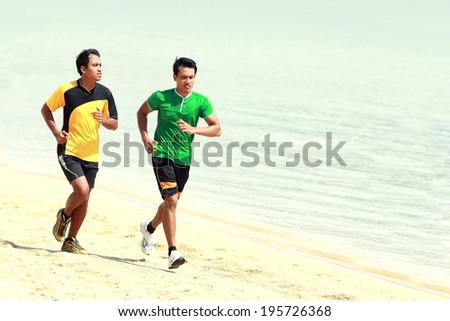portrait of two Man running on the beach